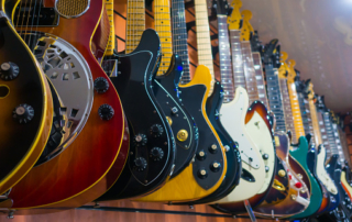 Different electric guitars hang in the music instruments store